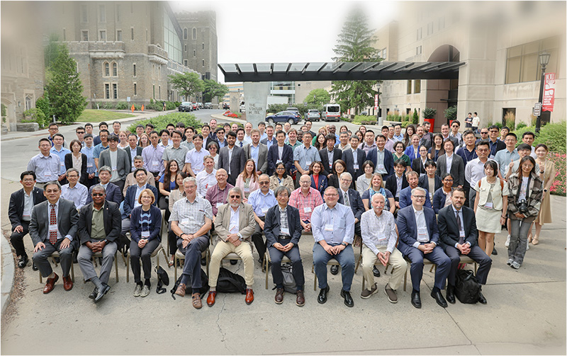 Conference attendees sit on chairs together in a group outside Statler Hotel.